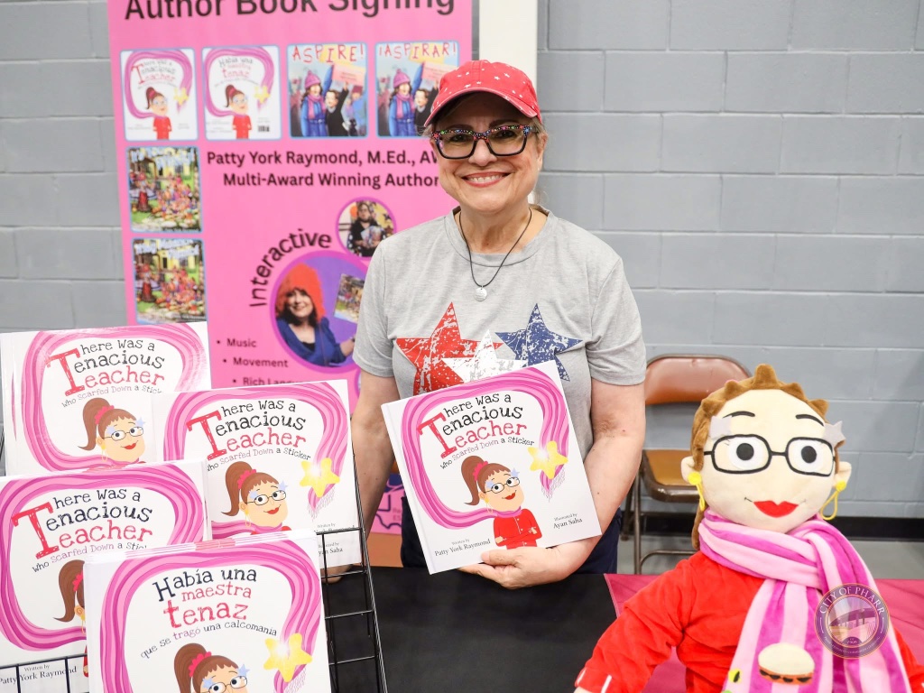 Award-winning author Patty York Raymond signs copies of her books, including 'There Was a Tenacious Teacher Who Scarfed Down a Sticker,' at the Lucha Libros 2025 author booth.
