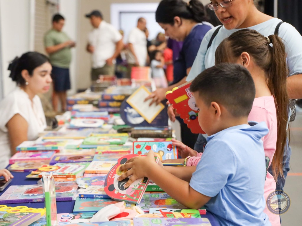 Young readers explore a wide selection of children's books at the Lucha Libros 2025 community book fair.