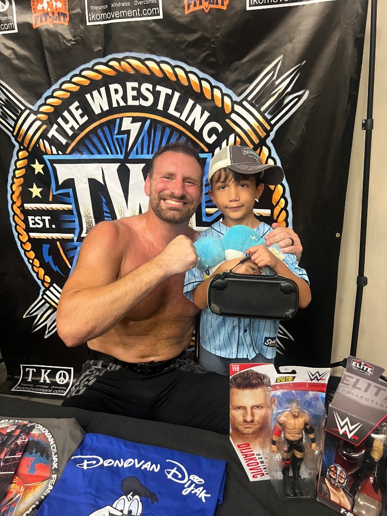 Wrestler Donovan Dijak poses with a young fan at the TWL meet-and-greet booth during Lucha Libros 2025.