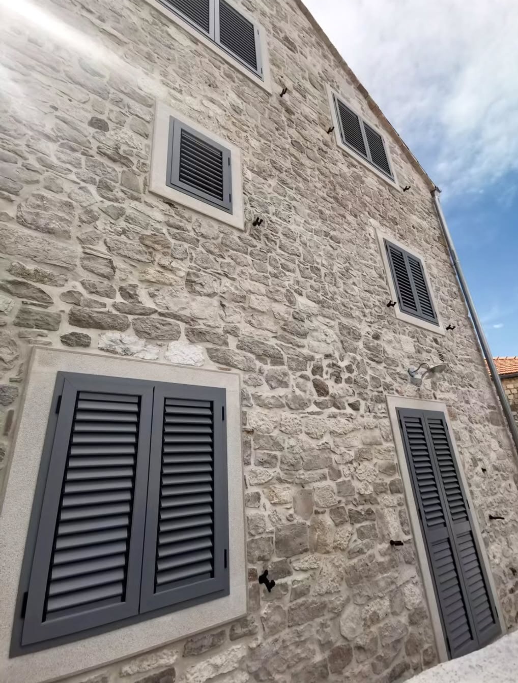 Kuća s prozorima i sivim kapcima