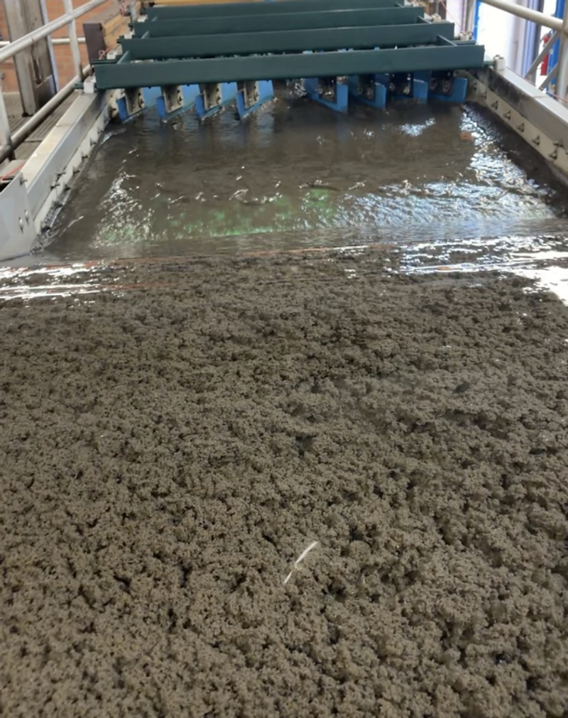 Industrial wastewater treatment tank channel with mechanical scraper