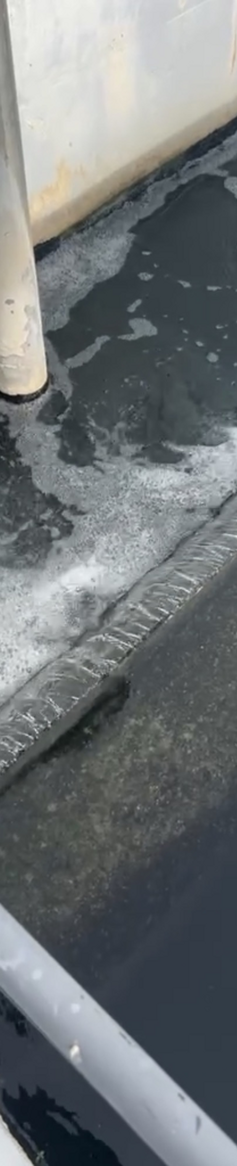 Wastewater treatment channel with weir and aerated foam