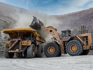 Heavy mining equipment loading a haul truck at a rare earth mine