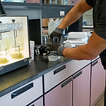 Lab technician characterizing process water at a bench with Nalgene beakers and a stirrer unit