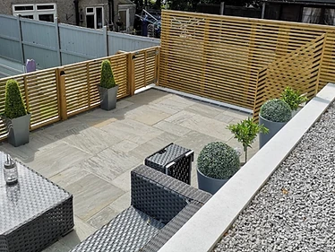 Kandla Grey Indian sandstone patio with rendered retaining walls and bespoke linear privacy trellis