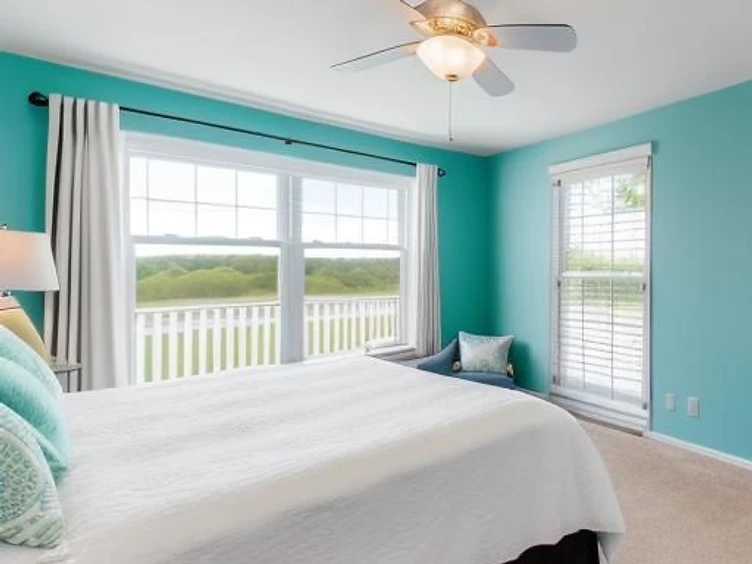 Bright coastal bedroom with turquoise walls and large window
