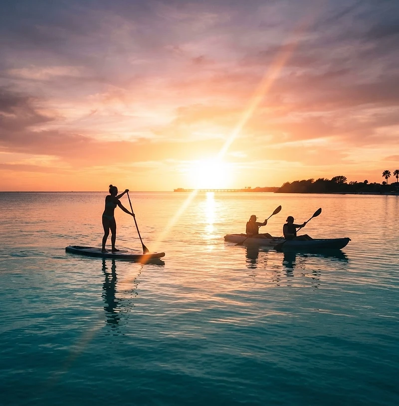 Paddleboard and kayak rentals on Clearwater Beach at sunset — Gulf Coast watersports