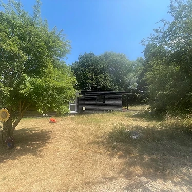 Cabin in the clearing by the trees