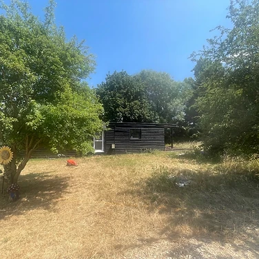 Cabin in the clearing by the trees