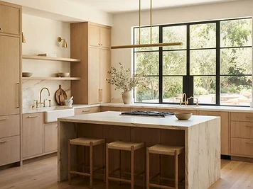 Remodeled kitchen with white oak cabinetry, honed stone counters, and warm natural light