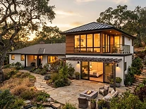 Modern home addition wing with large windows at evening light in an East Bay neighborhood