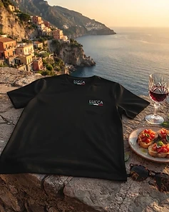 Camiseta LUCCA preta em muro de pedra com bruschetta e vinho ao pôr do sol