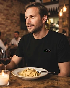 Camiseta LUCCA preta — homem em restaurante italiano com vinho e pasta