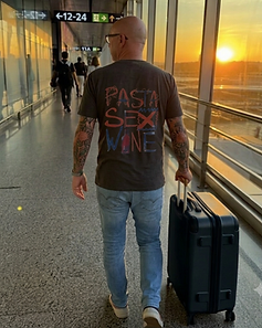 Camiseta LUCCA cinza — homem em terminal com mala ao pôr do sol