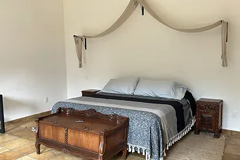 Recámara con cama y baúl de madera