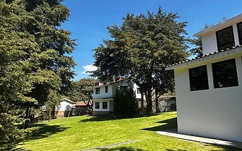 Jardín con sendero de piedra y casa de campo