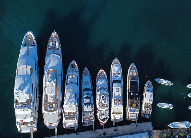 Aerial top-down view of yachts docked side-by-side at a Caribbean marina with deep turquoise-blue water