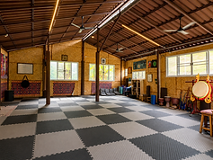 NERS House Activity & Practice Space A flexible space equipped with mats, cushions, traditional drums, musical instruments, and wellness activity props for movement, meditation, sound, and group practice.