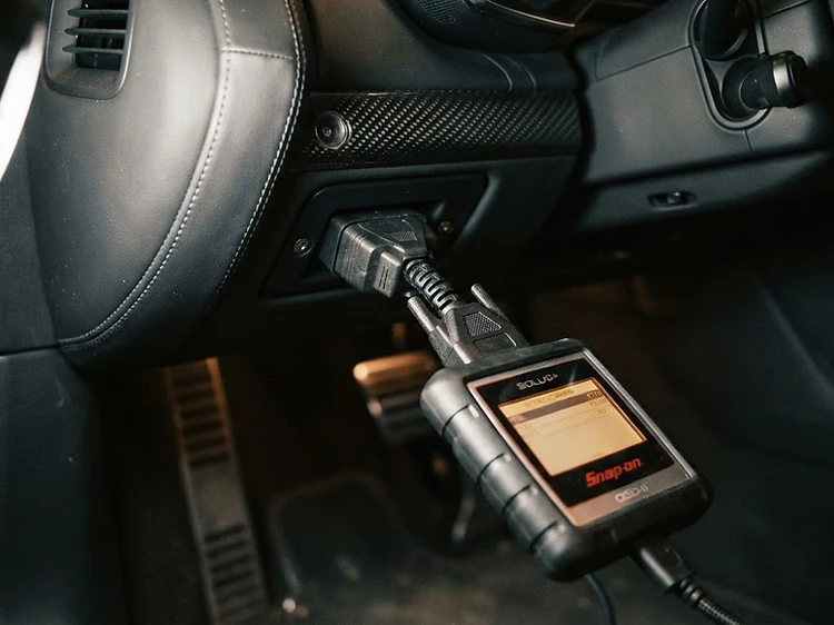Professional diagnostic scanner connected to a vehicle for on-site diagnostics