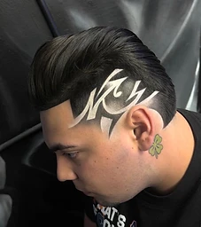 Slicked-back fade with tribal design shaved into the side