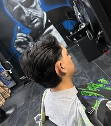 Tapered fade with styled volume on top, profile shot in the chair