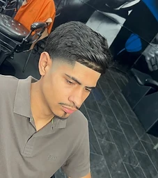 Textured taper fade profile in front of the Godfather mural