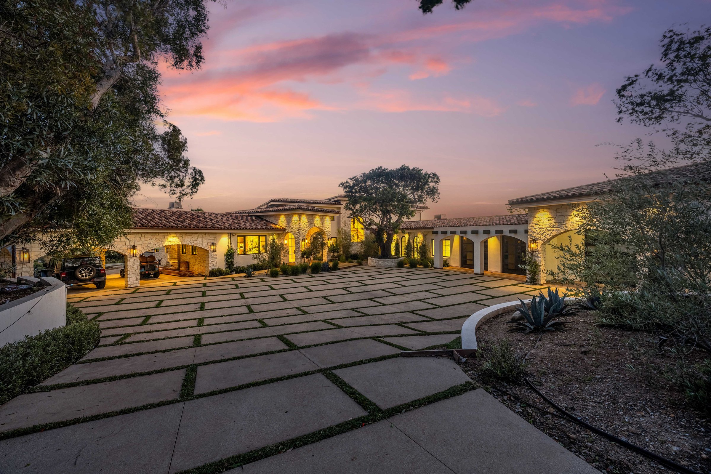 The motor court at dusk, framed by the lit wings of the house, Merritt Estate in Malibu by Apel Design
