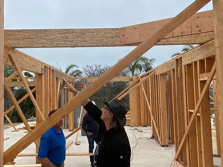 Explaining a timber brace to the team inside a framed structure