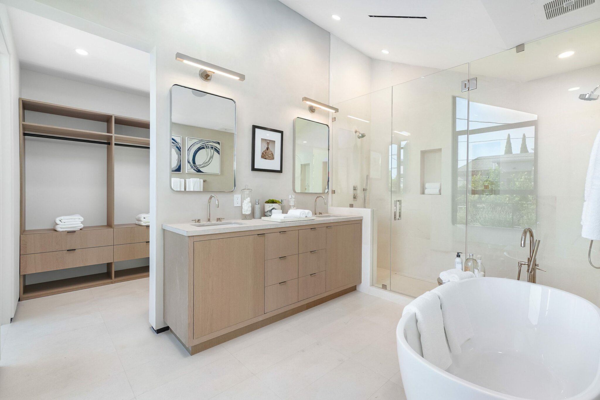 Bathroom at Ashcroft with an oak double vanity, a freestanding tub and the dressing room beside it, by Apel Design