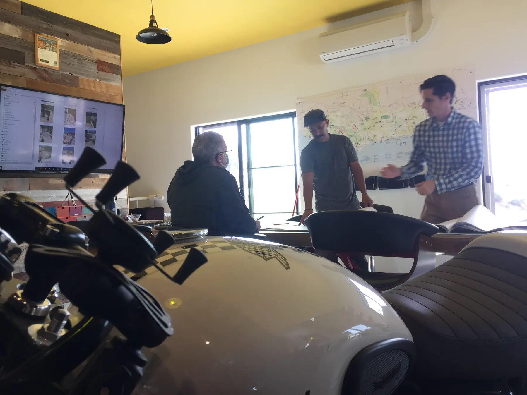 A project discussion in the Apel Design conference room, with the regional map on the wall