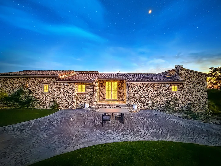 Pool terrace and illuminated residence in the evening