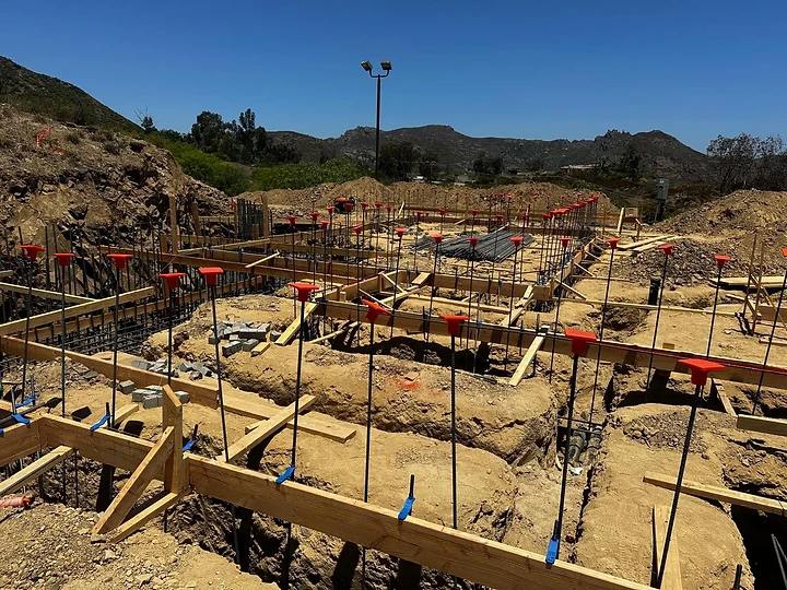 Foundation rebar and formwork laid out on a hillside site