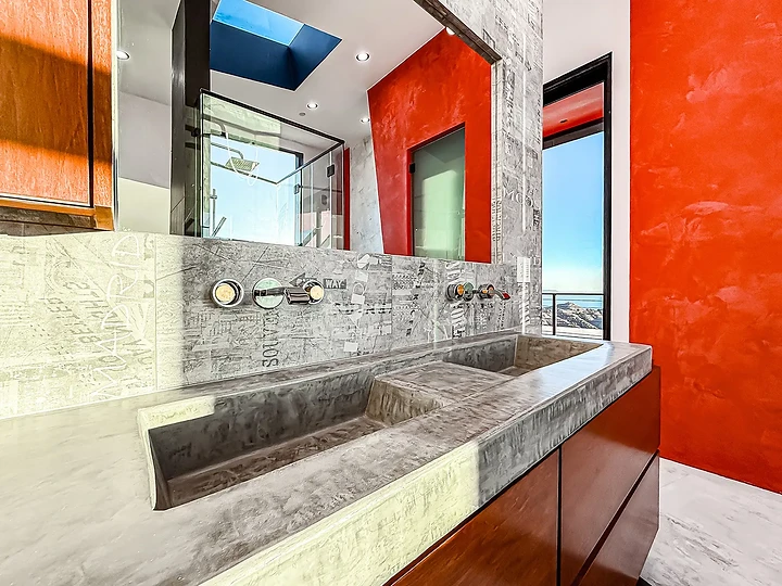 Cast concrete sink against an orange wall at The Aviator