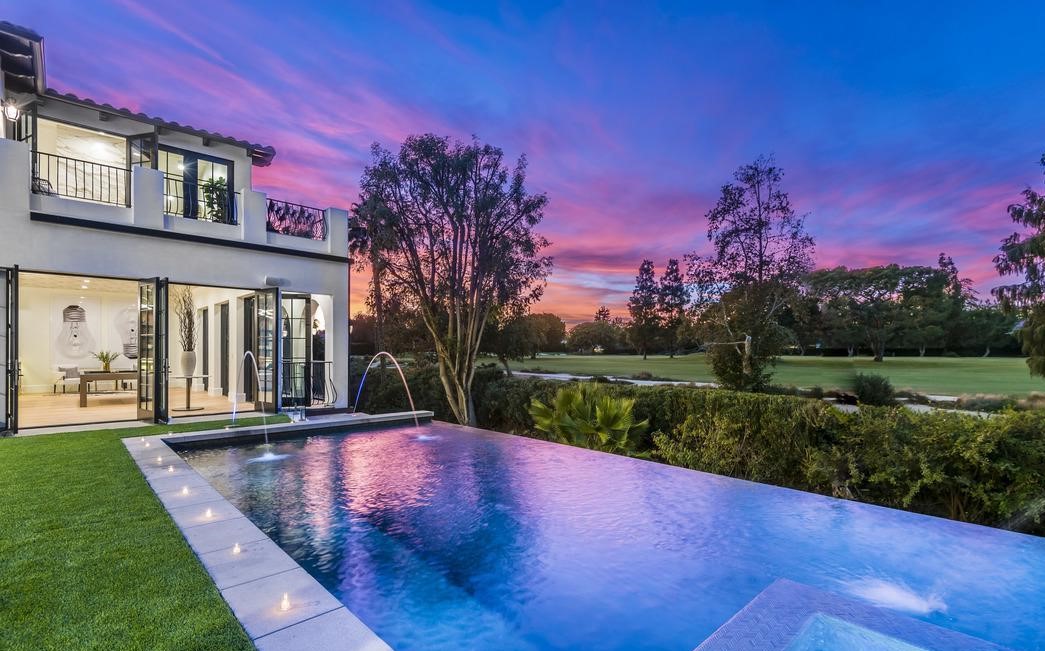 Pool and lawn at dusk at a home by Apel Design in Hancock Park