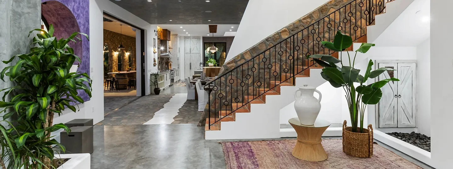 The stair hall and rooms beyond, across a polished gray floor, at Maliview in the Malibu Mountains, by Apel Design