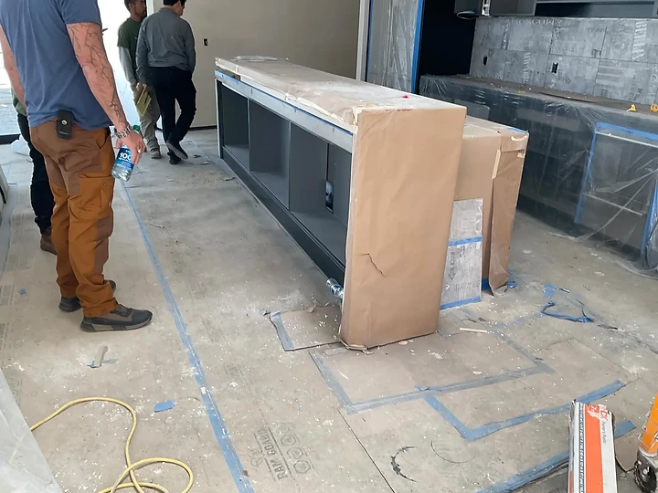 Installing cabinetry during finish work on a residence