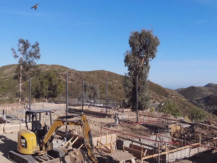 A hummingbird over a foundation-stage site in the Malibu hills