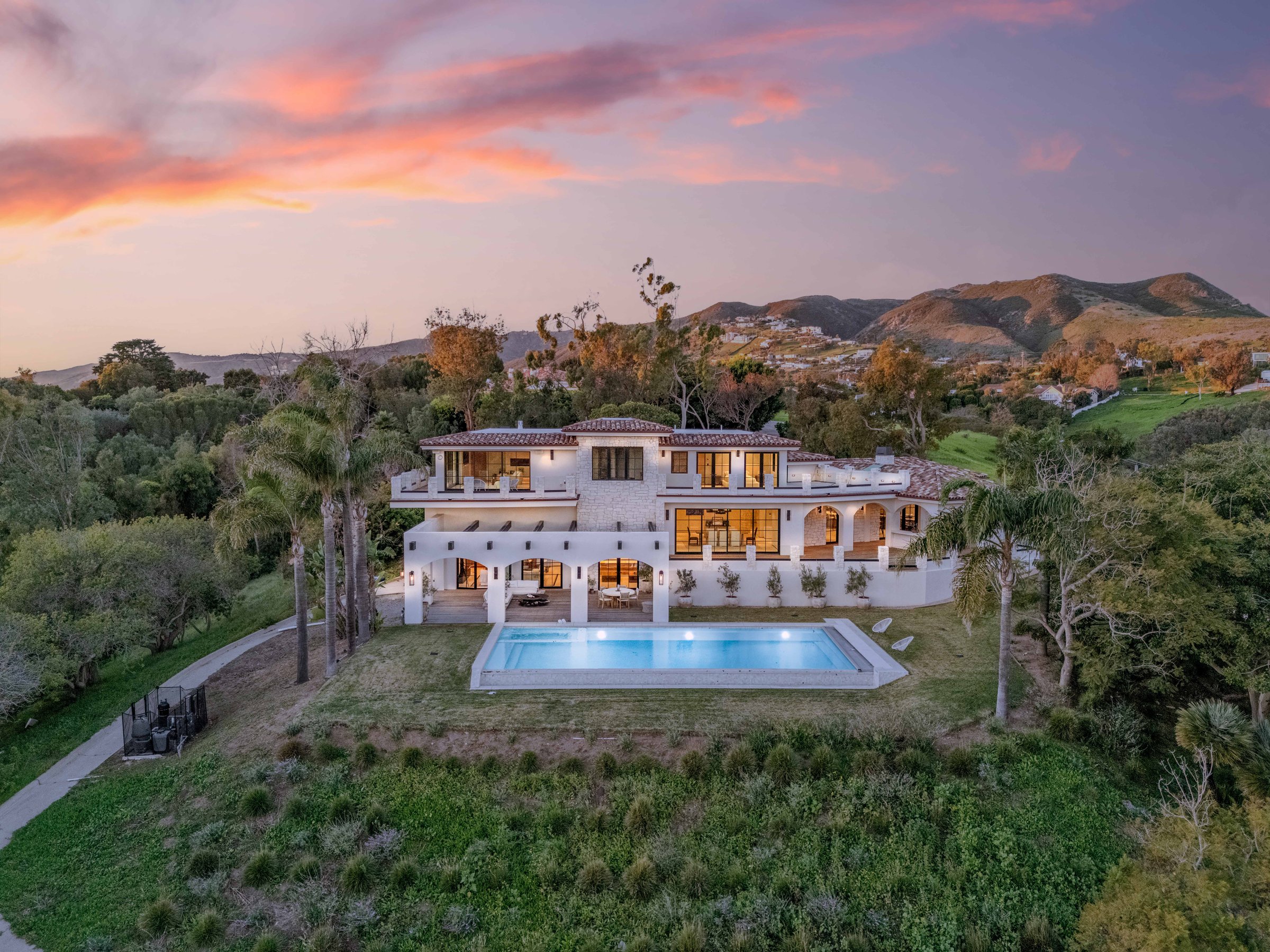 The house at dusk, with the Santa Monica Mountains behind, Merritt Estate in Malibu by Apel Design