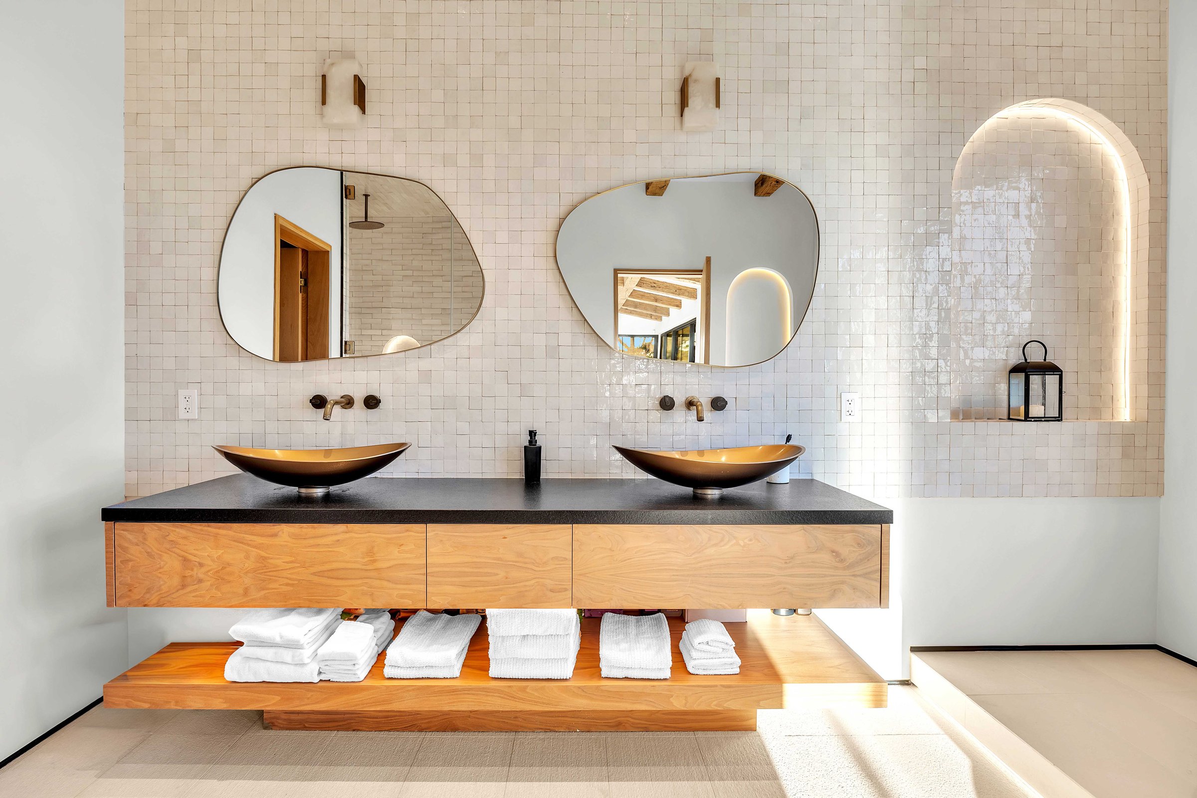 Twin vessel basins under glazed tile and a lit arched niche, Merritt Estate in Malibu by Apel Design