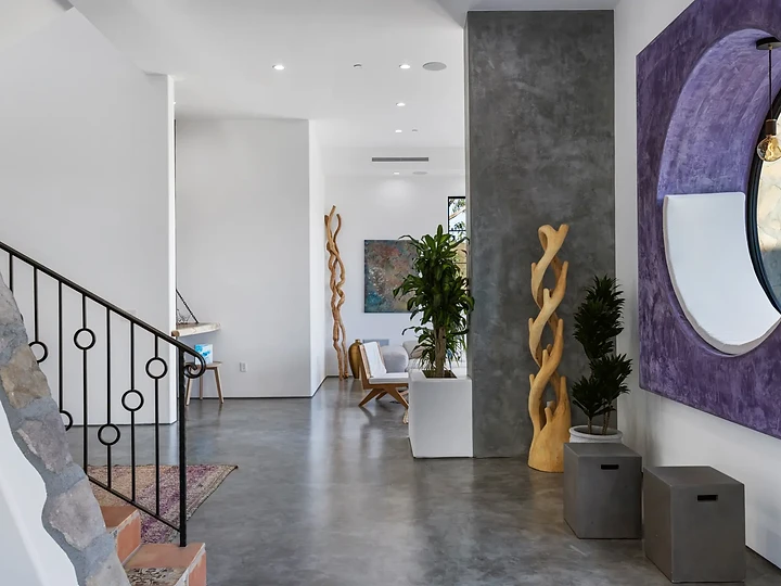Polished concrete hall with a stone stair wall and a violet panel, at Maliview in the Malibu Mountains, by Apel Design