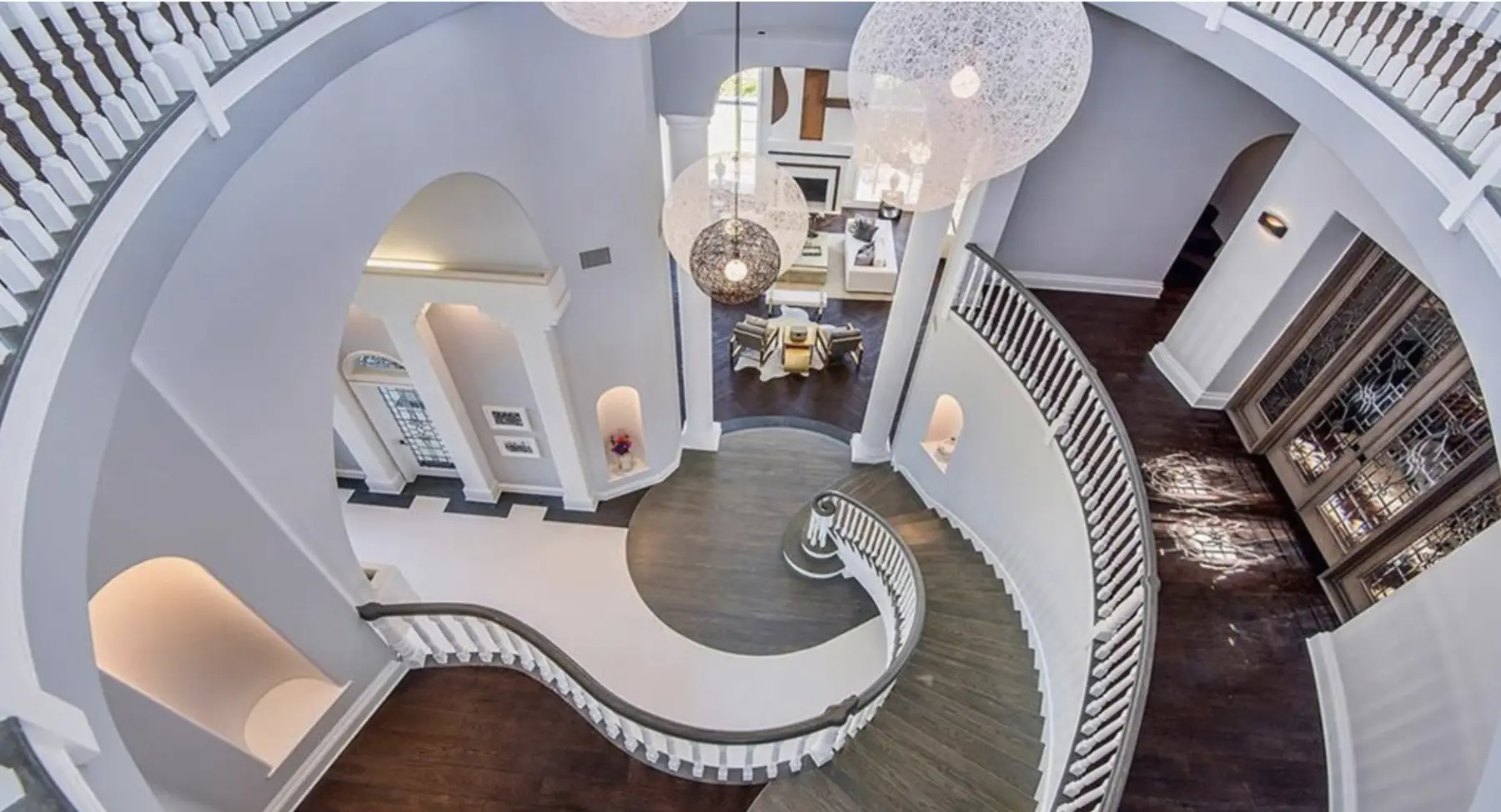 Curving stair and white balustrade seen from above, an interior by Apel Design