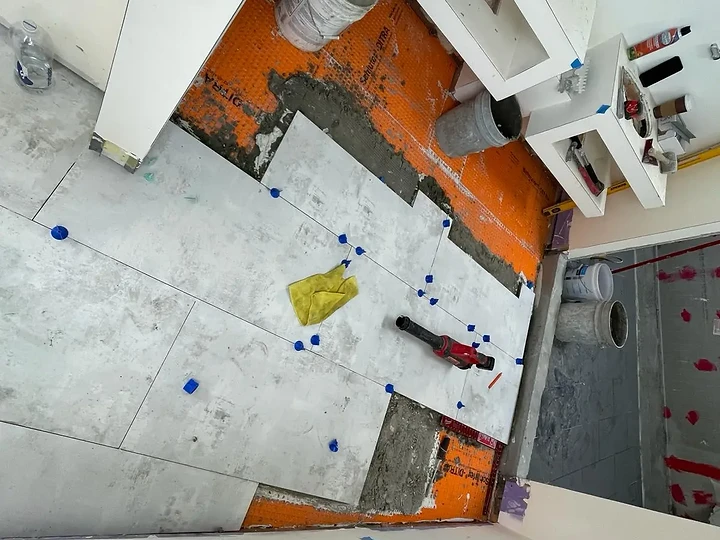Large-format tile being set over waterproofing at The Aviator