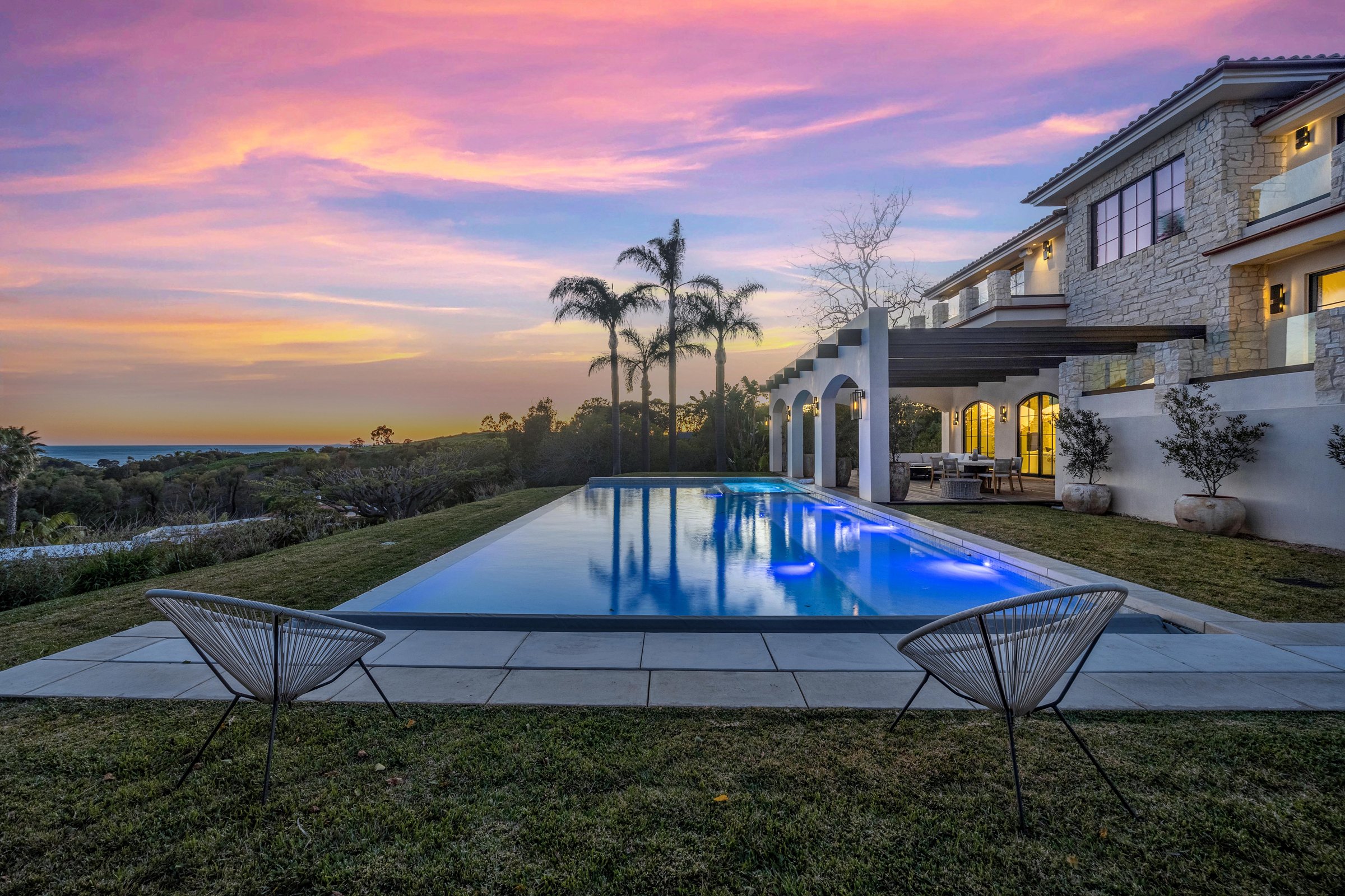 The pool at sunset, with the arched loggia and the upper terraces beyond, Merritt Estate in Malibu by Apel Design