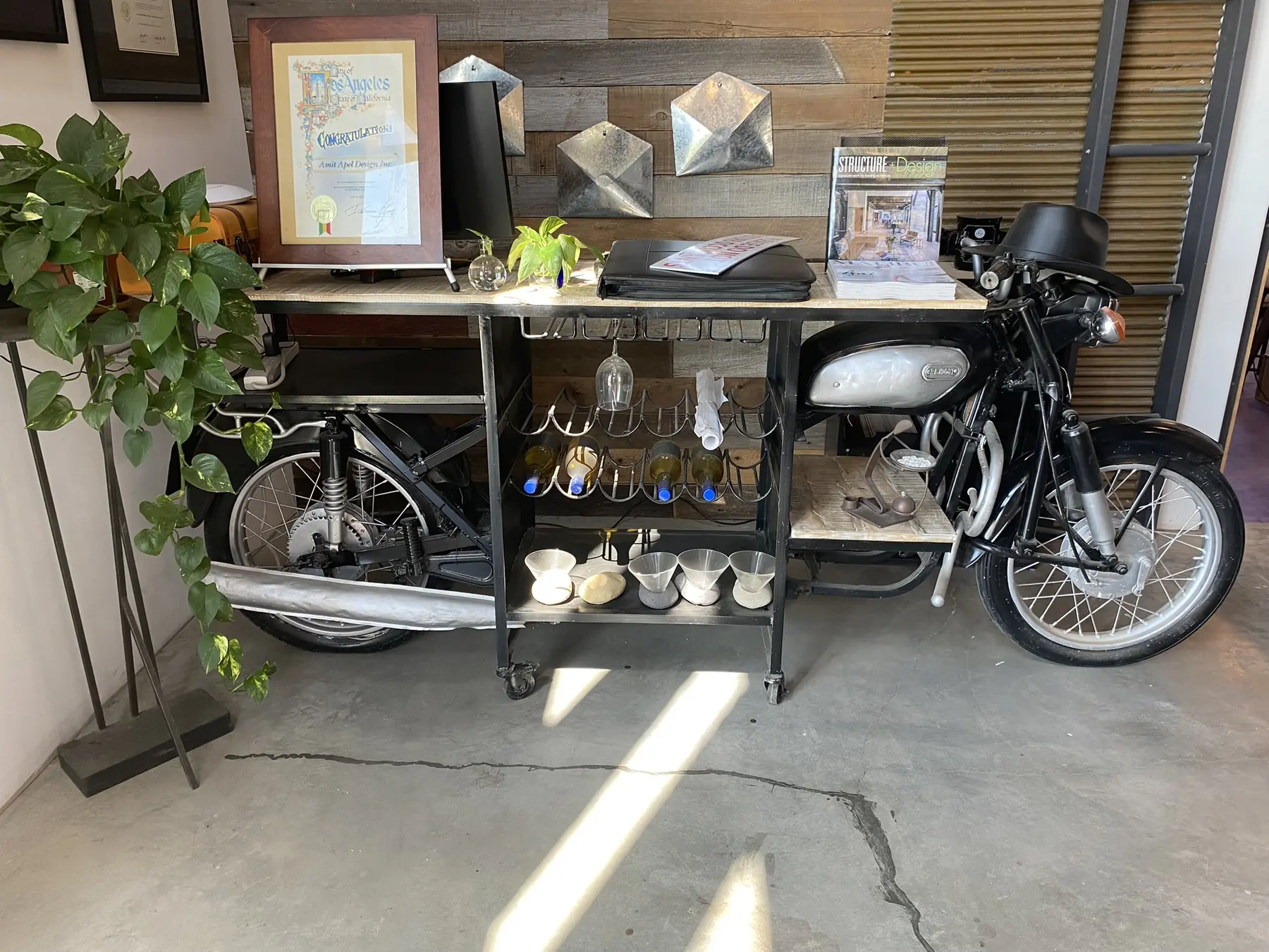 A restored vintage motorcycle repurposed as a bar cart inside the studio