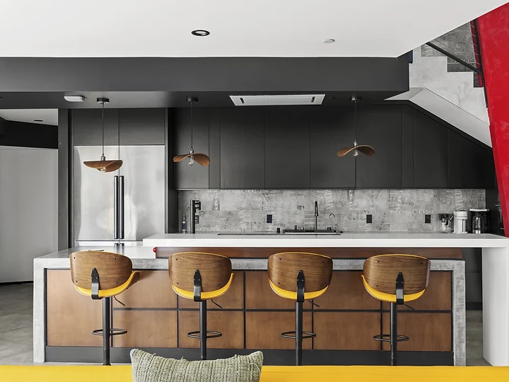 Bar seating in front of black cabinetry and a stone backsplash, at The Aviator in Malibu, by Apel Design