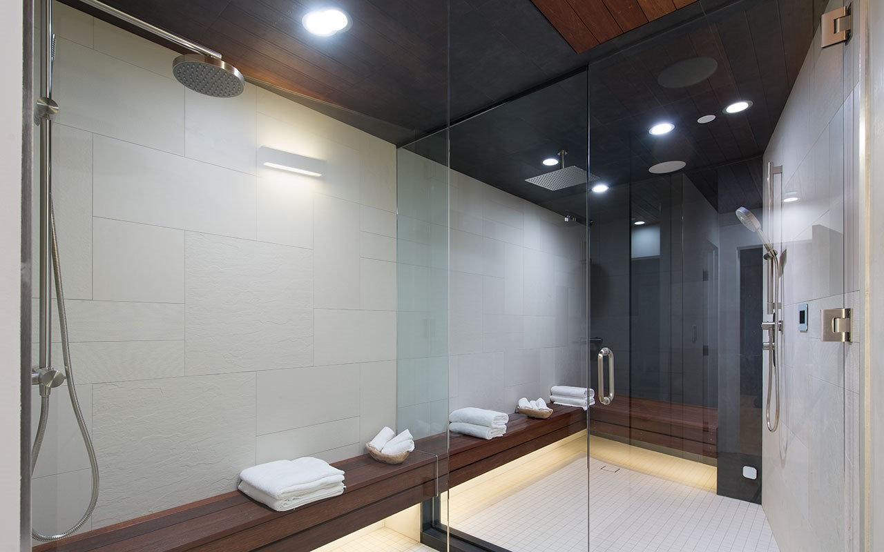 Shower room at Shoreham with wood bench, wood-lined ceiling and twin rain heads, by Apel Design