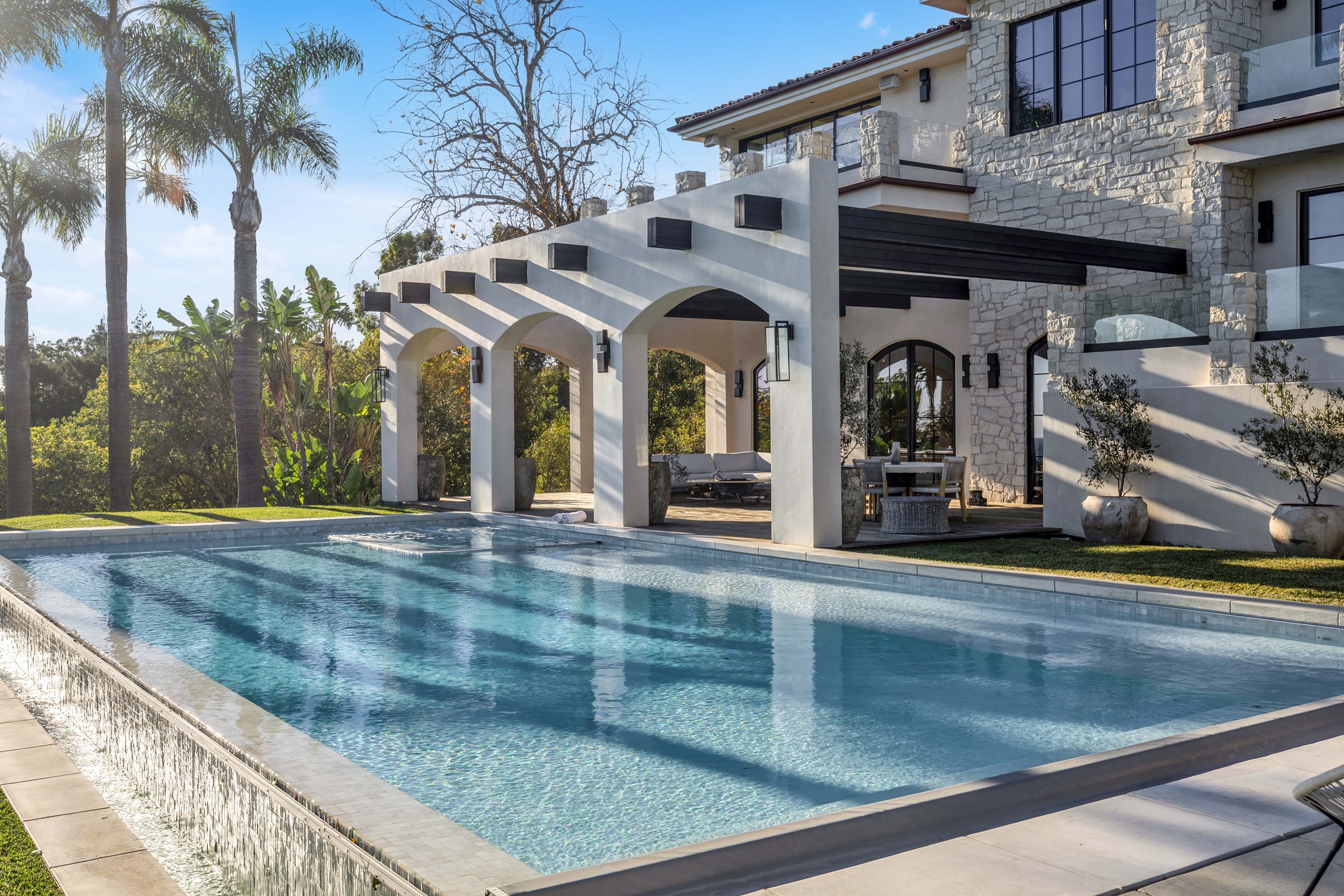 The pool and its vanishing edge beside the arched pavilion, Merritt Estate in Malibu by Apel Design