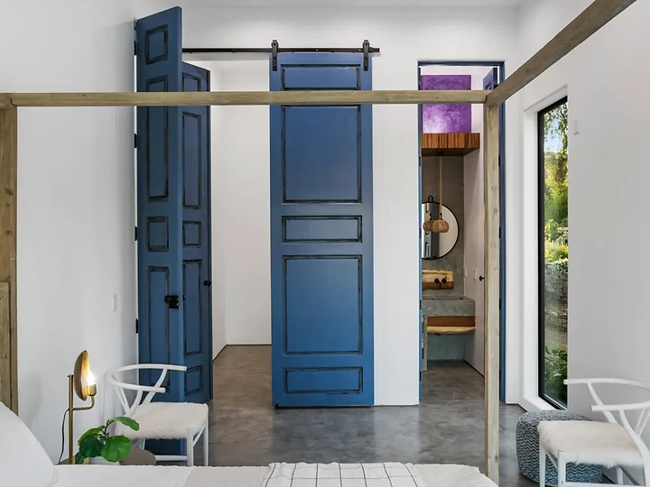 Blue doors and brass rail in a dressing room at Maliview