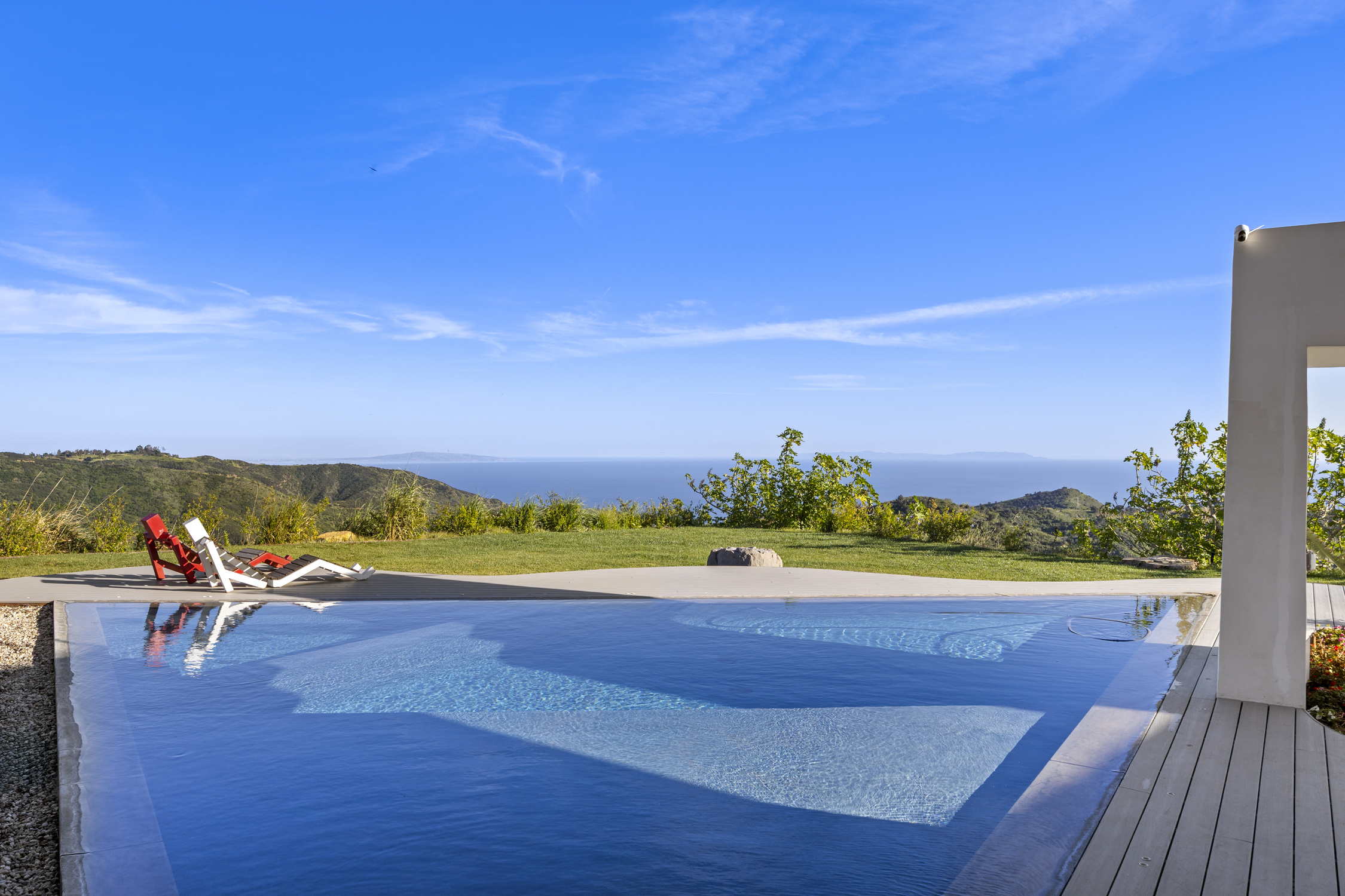 Infinity pool and lawn above the ocean at a Malibu residence by Apel Design
