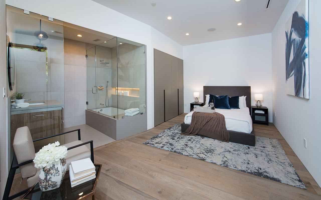 Bedroom at Shoreham with glass-enclosed bath and full-height wardrobes, by Apel Design